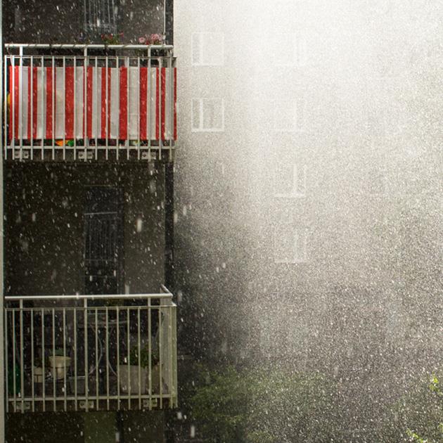 Stört regn framför ett bostadshus